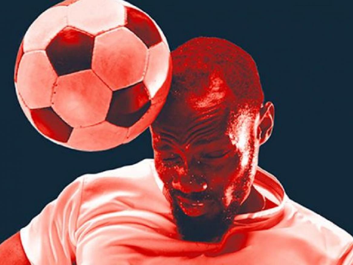 Stock image of soccer player getting hit in the head by a soccer ball.