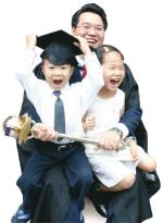 Macebearer William Yong Tieng Lee, and children Han Kwang (left) and Wen Kym celebrate his achievement
Photo Ben Osborne