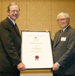 Dr Tony Tan (right) receives his Distinguished Alumni Award from University Chancellor the Honourable John von Doussa
Photo Ben Osborne