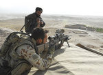 An Australian soldier scans the surrounding area for threats as a local man watches on during a patrol in Afghanistan
Photo by the Department of Defence