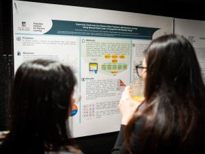two women looking at research poster