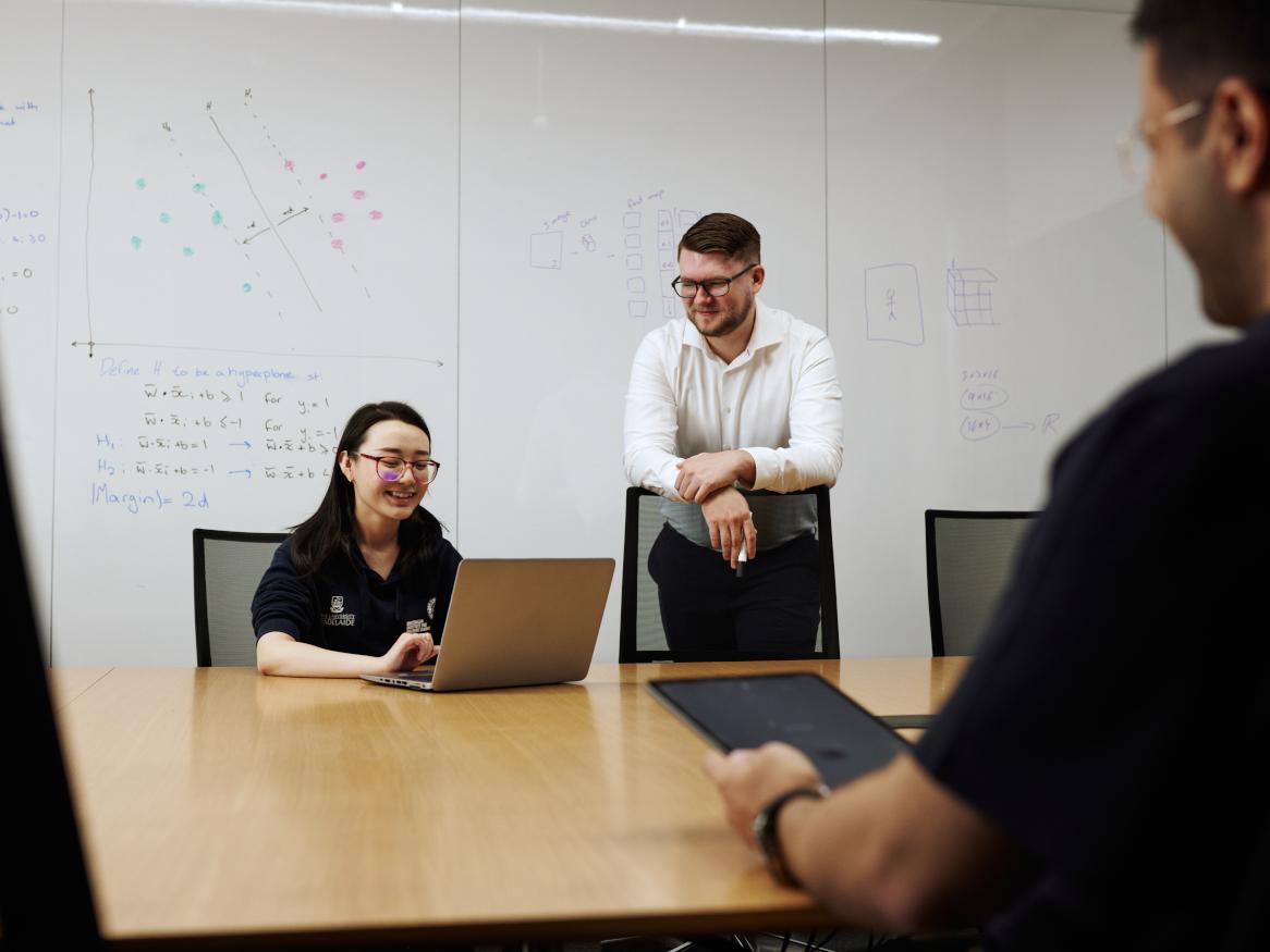 three people working in a meeting room