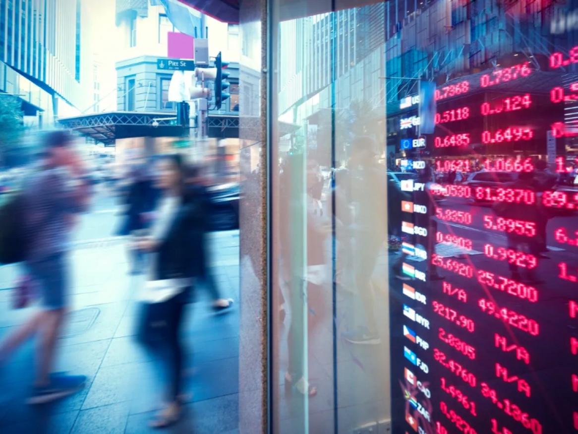 People walking by next to a wall of data