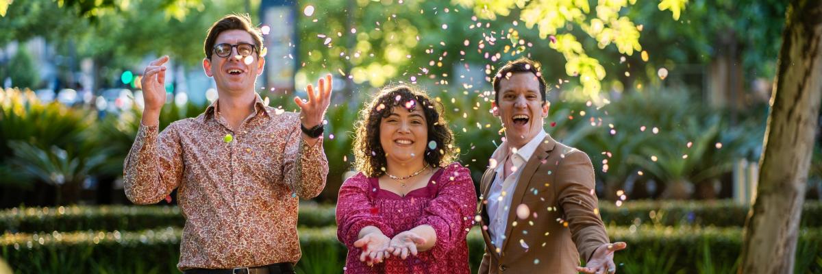 Three people celebrate outside with sparkles!
