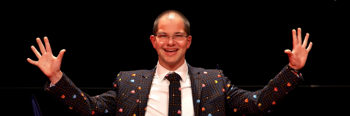 Andrew Pfeiffer headshot. He's wearing a pac man suit and smiling widely.