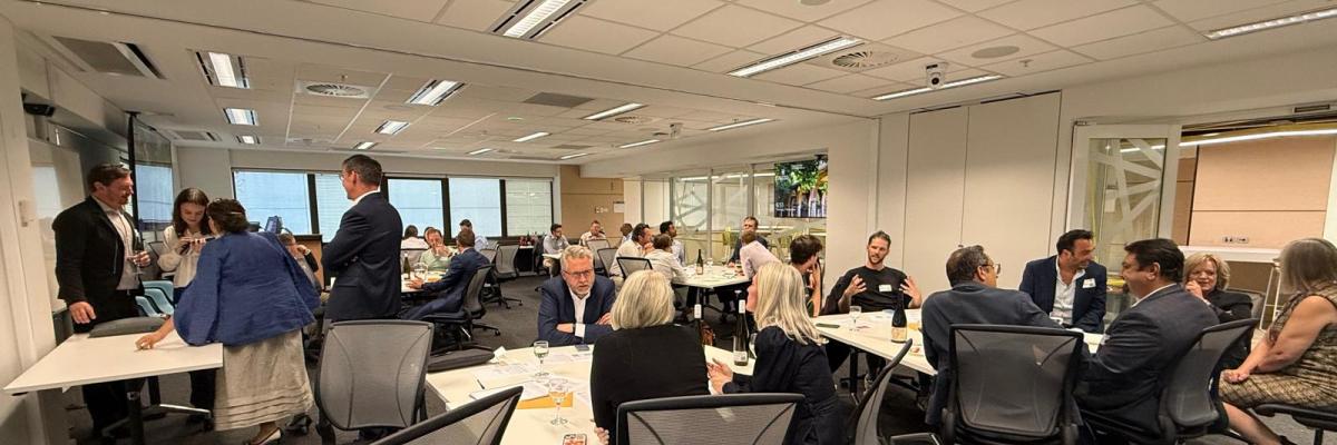 A large room in which groups of professionals are in animated conversation