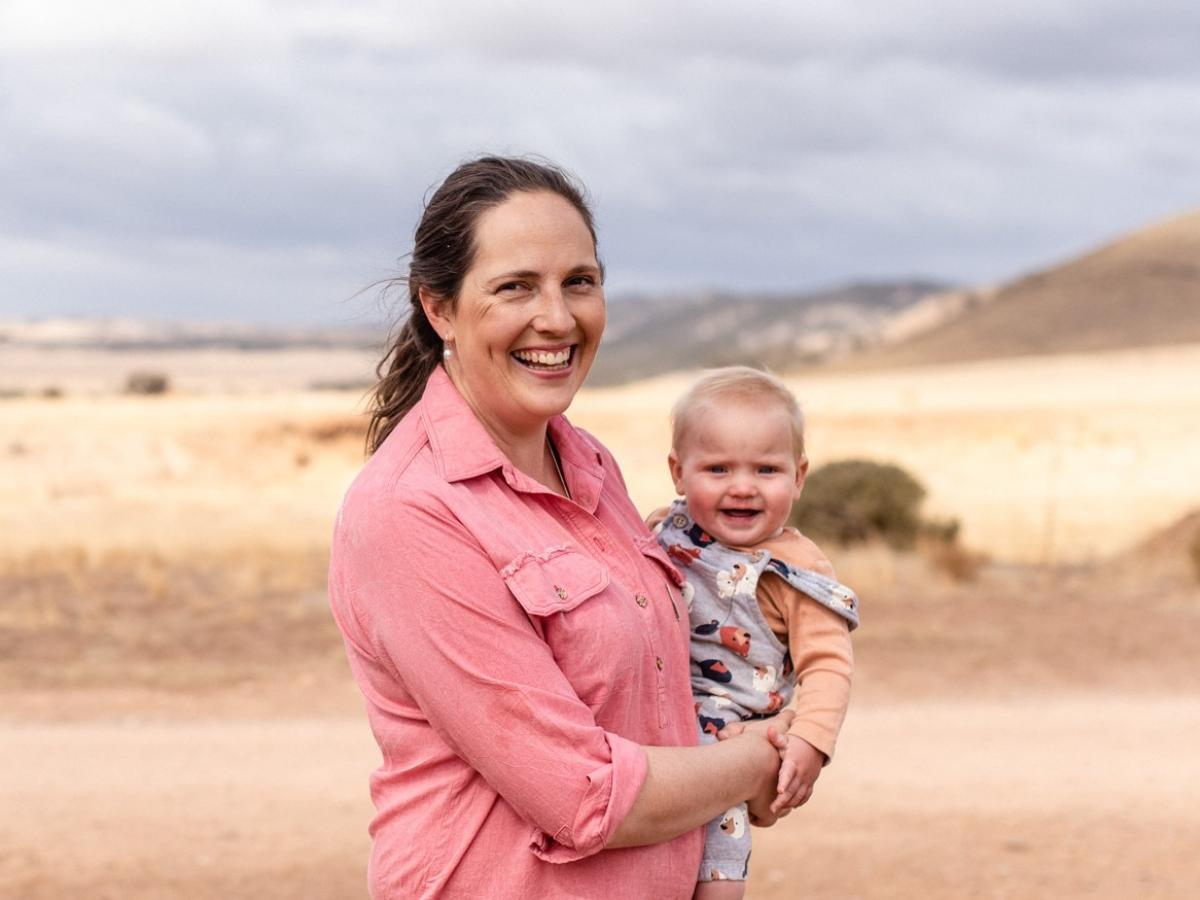Stephanie Schmidt holds baby son Darcy in a paddock