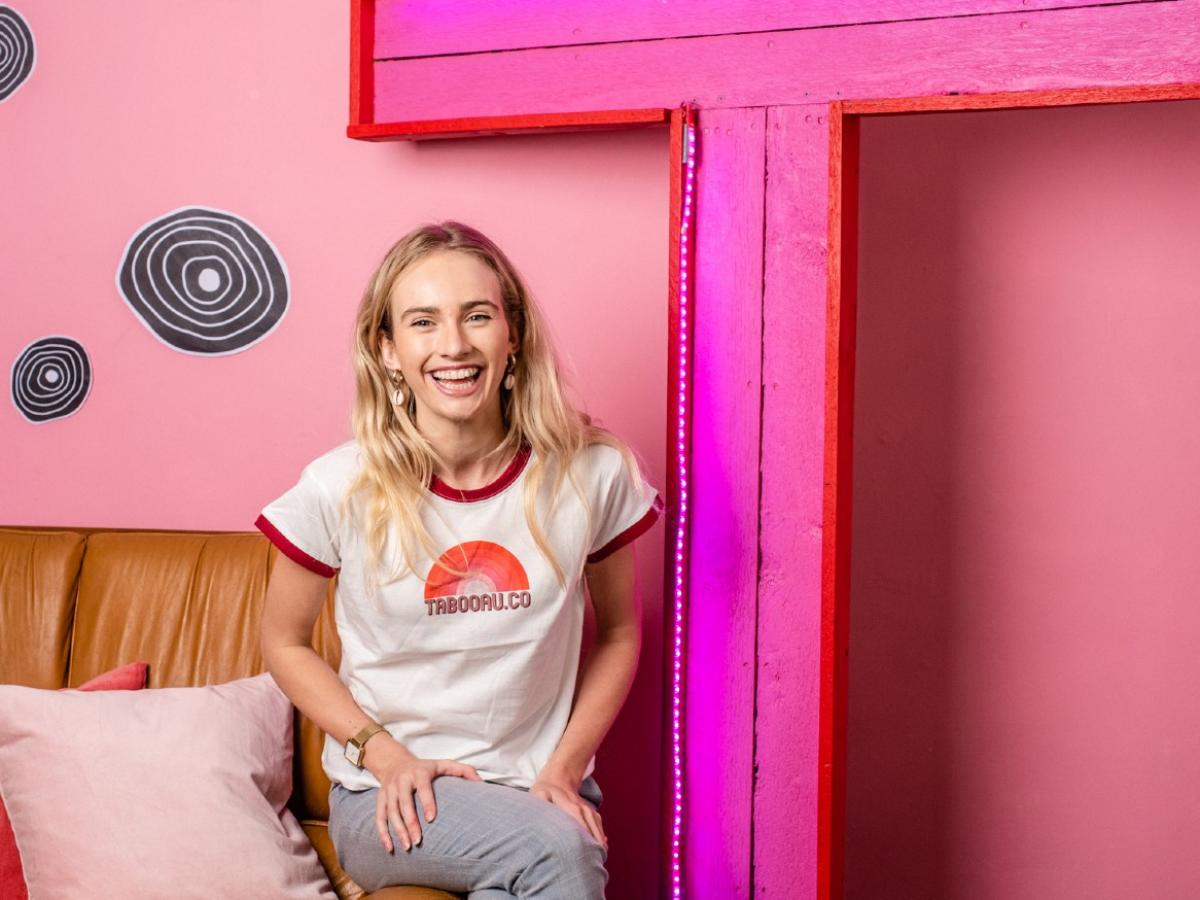 Isobel Marshall at TABOO headquarters sitting by a giant pink letter T