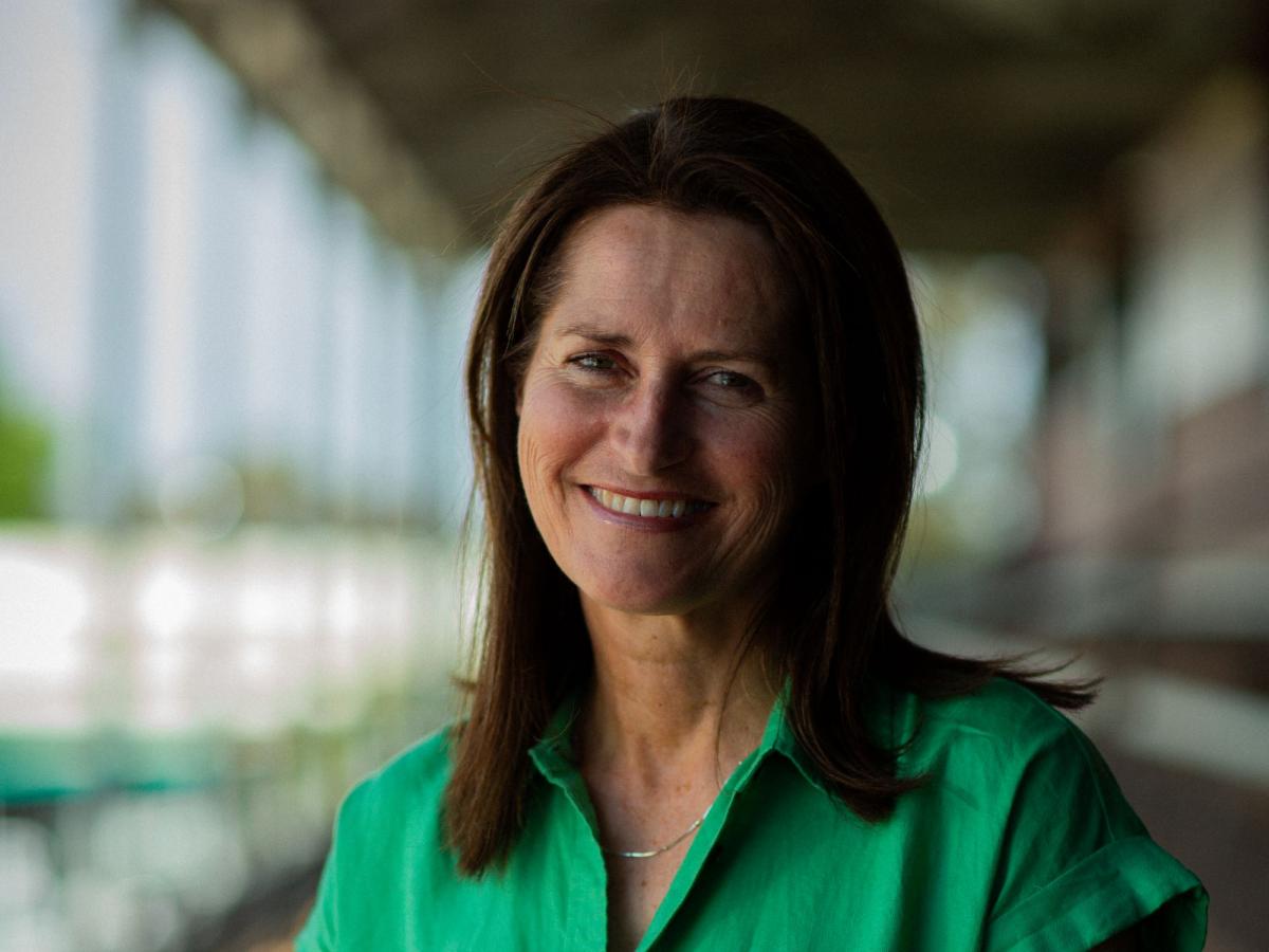A portrait of Juliet Haslam in a bright green shirt