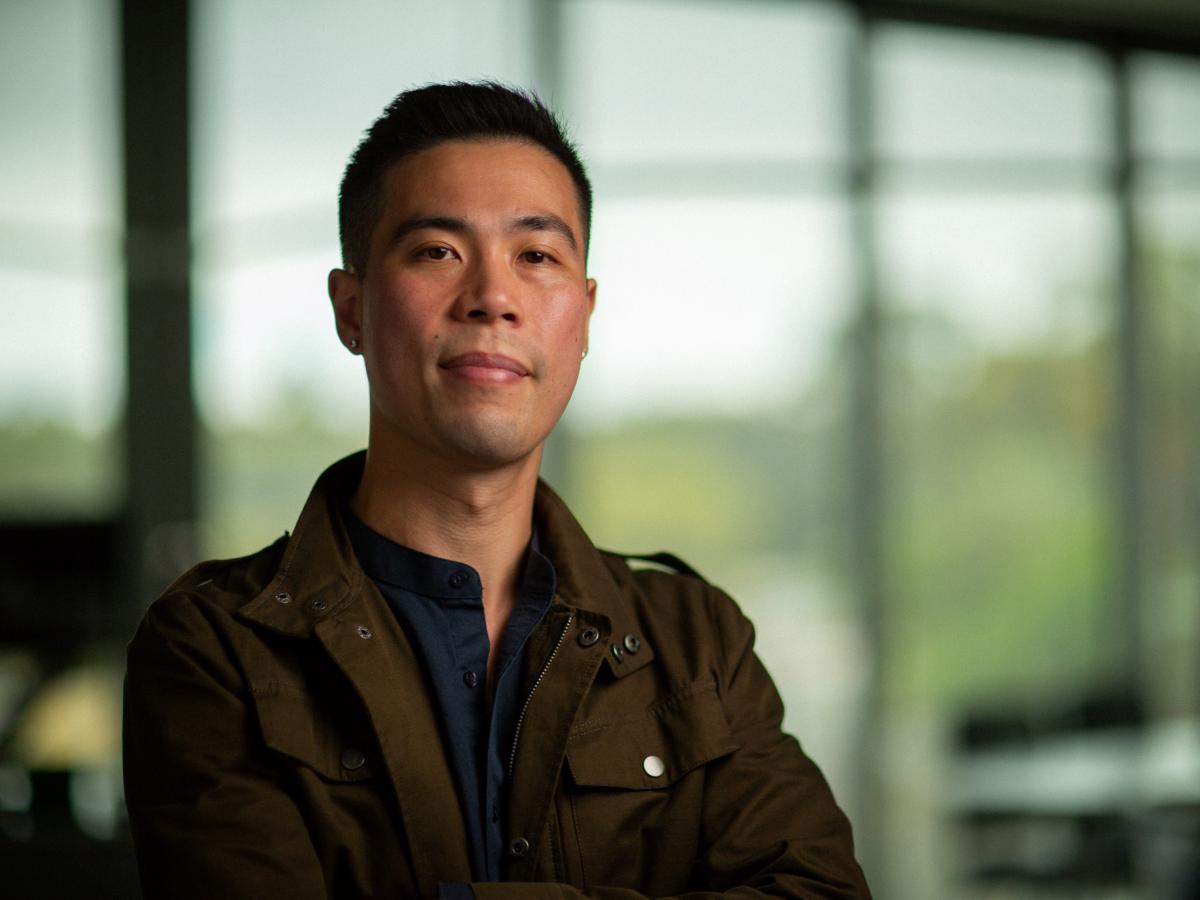 A headshot of Dr Lam in a khaki jacket