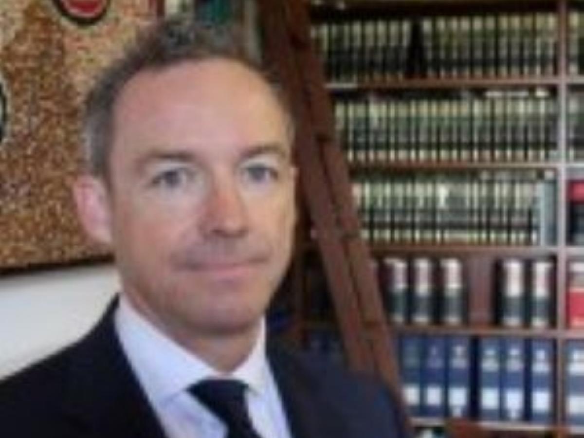 A portrait of Damian O'Leary in a library