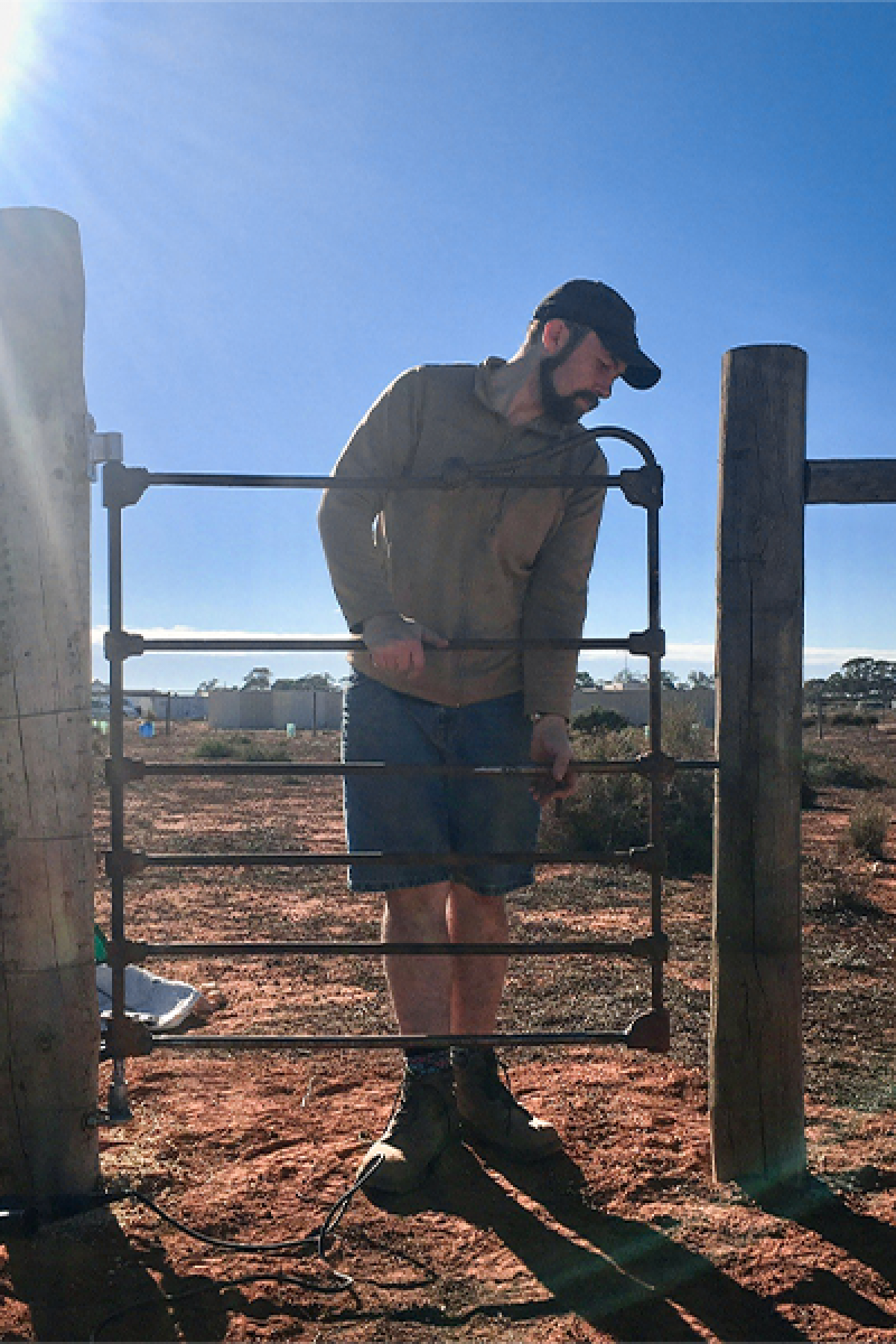 Alex hanging a gate on his property in the Murray Mallee where he is regenerating the land with his partner Aurelia