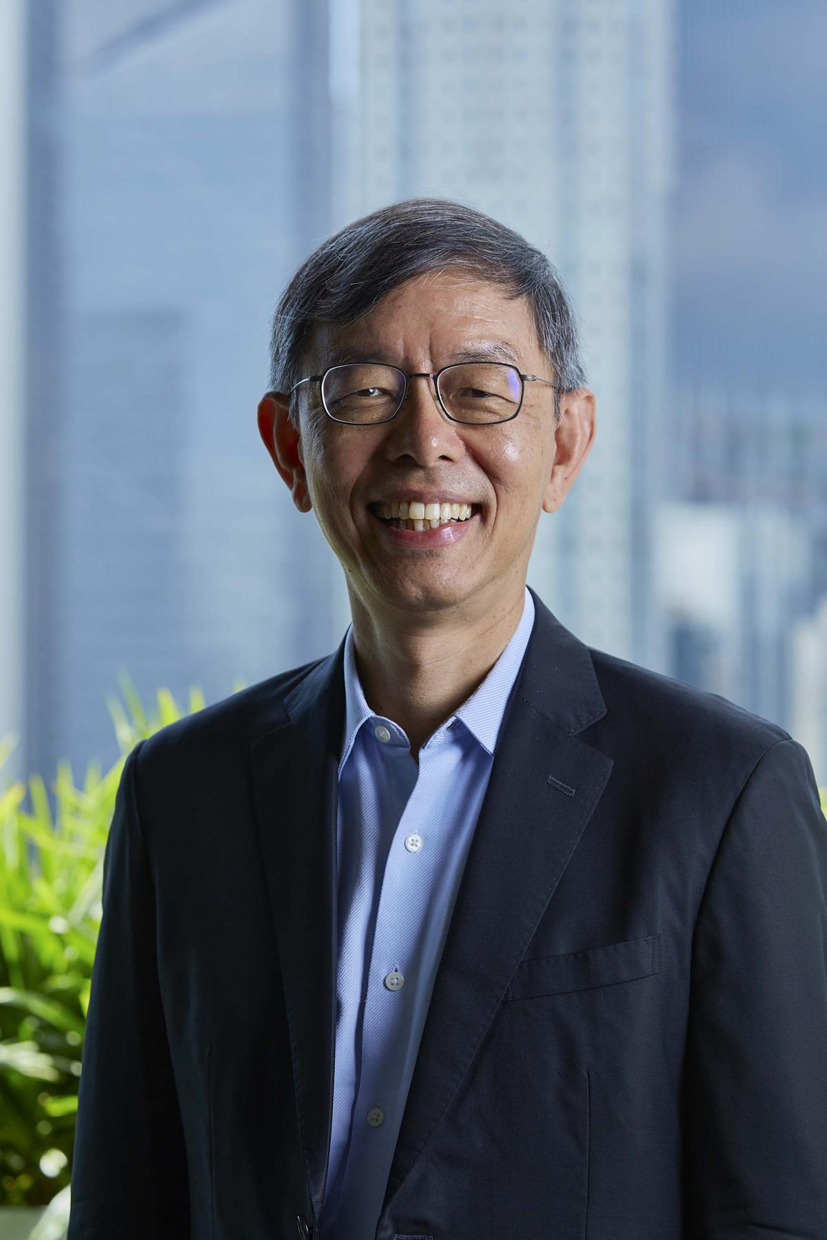 A portrait of Peter Ong smiling, wearing a suit