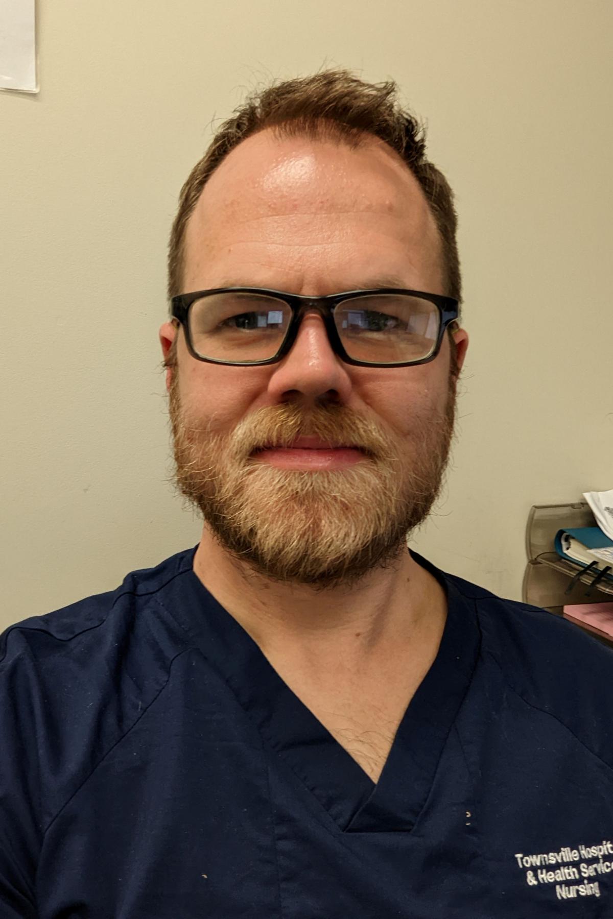 A portrait of Phil in his scrubs