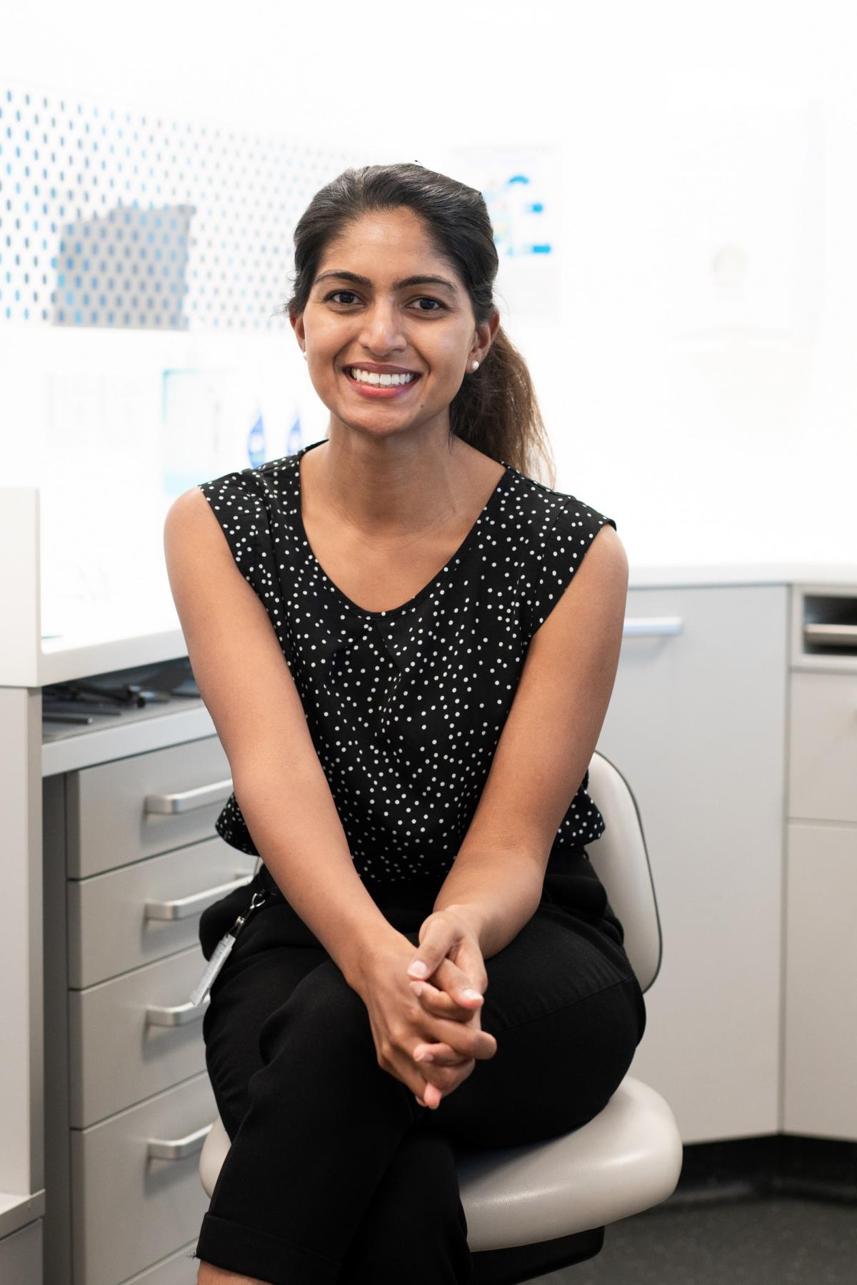 A portrait of Dr Kumarasinghe smiling in a dental office
