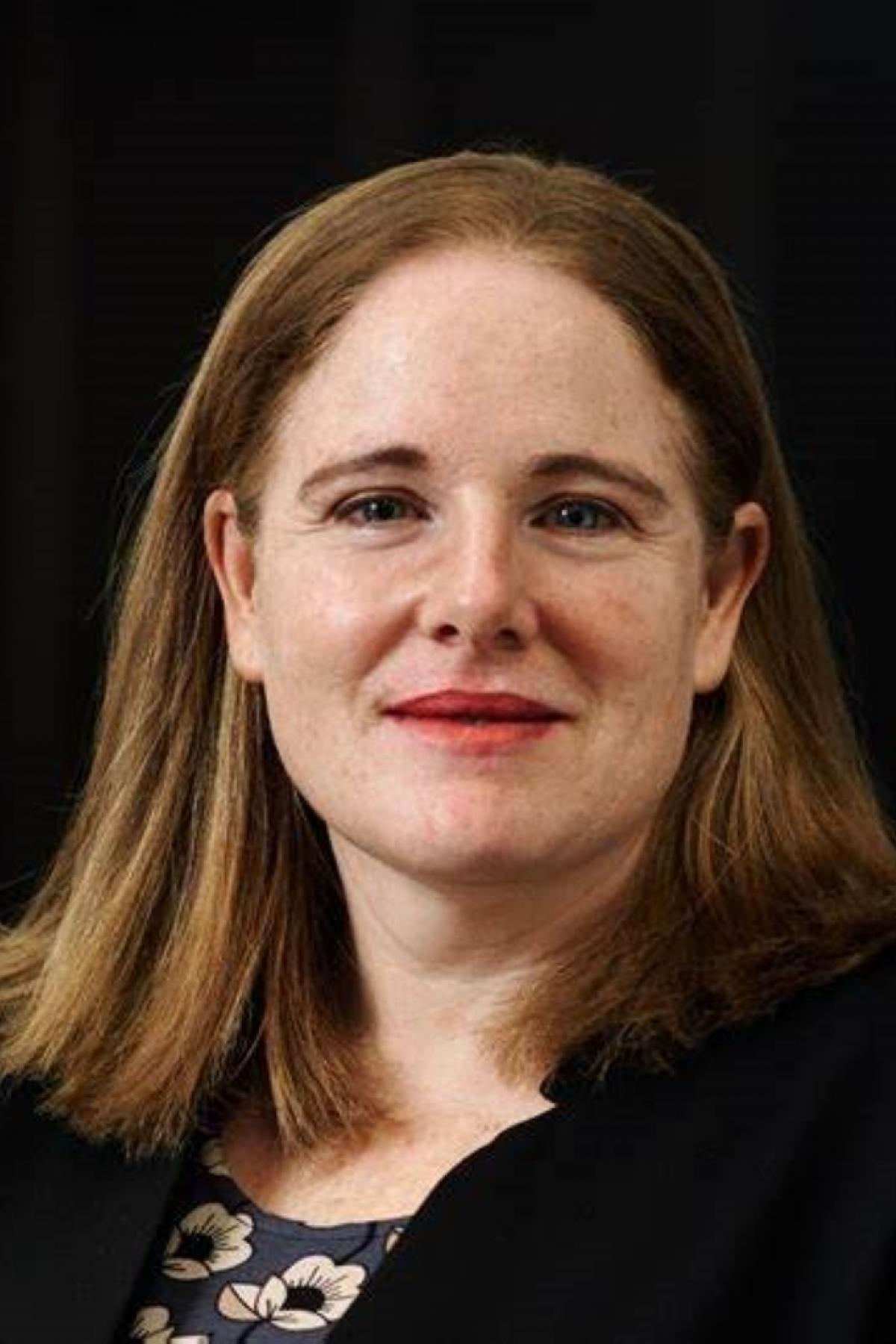 A portrait of Kathy smiling softly