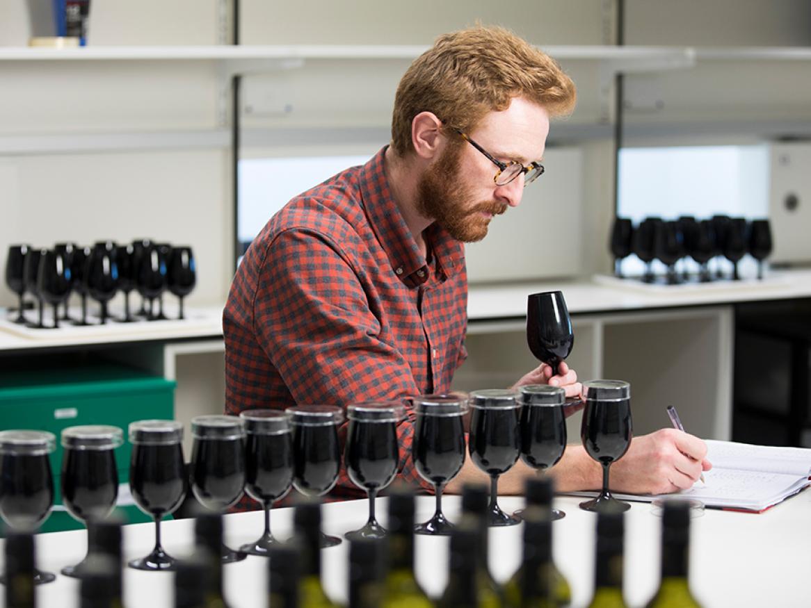 man trying wine in a wine lab