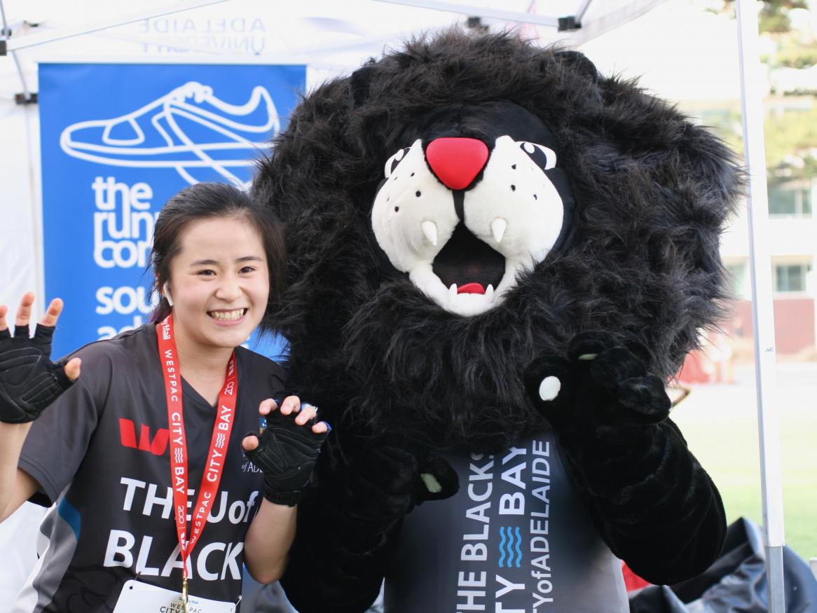 A participant of city to Bay with the AU Sport Black's mascot
