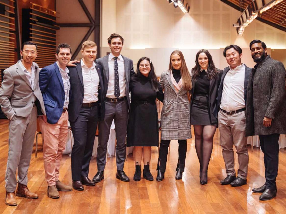 Young alumni committe in 2021 standing together at the winter warmer event