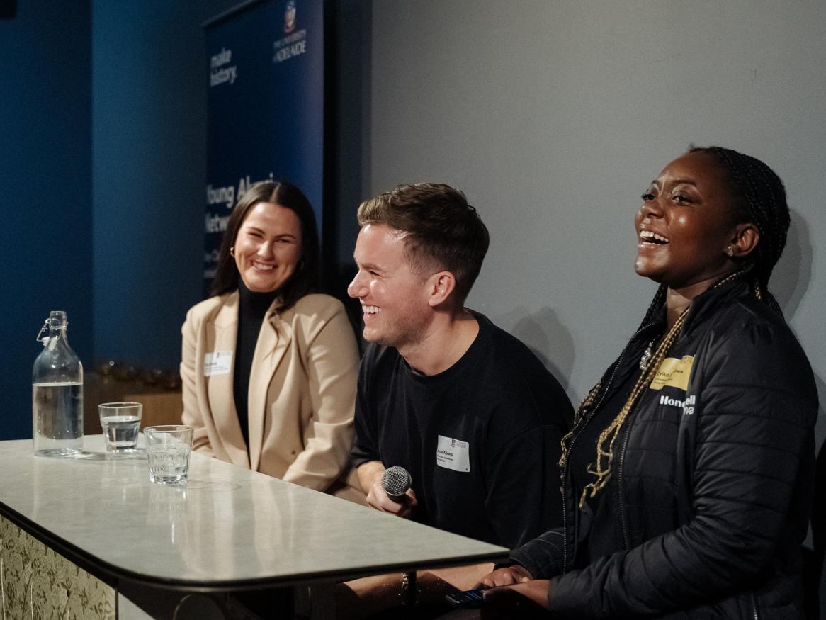 Three panellists laughing during a presentation at the Winter Warmer event