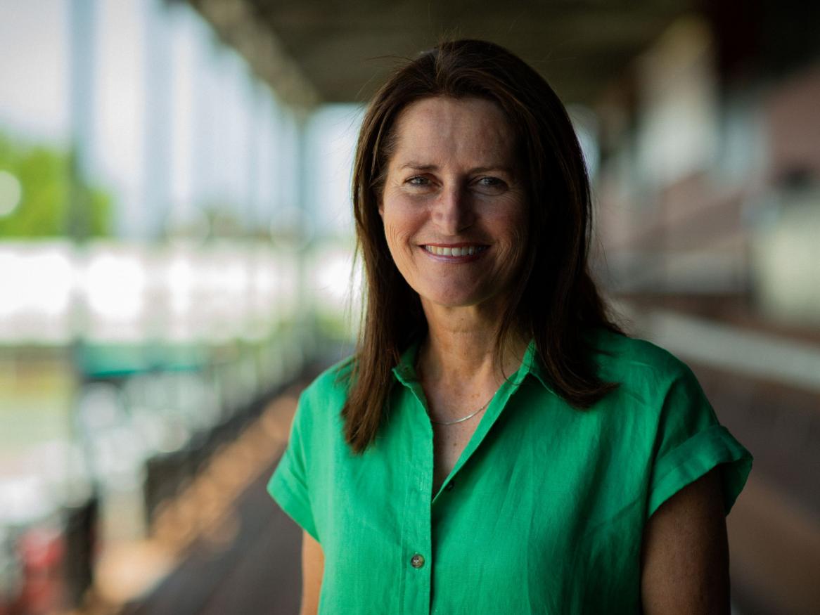 A portrait of Juliet Haslam in a bright green shirt