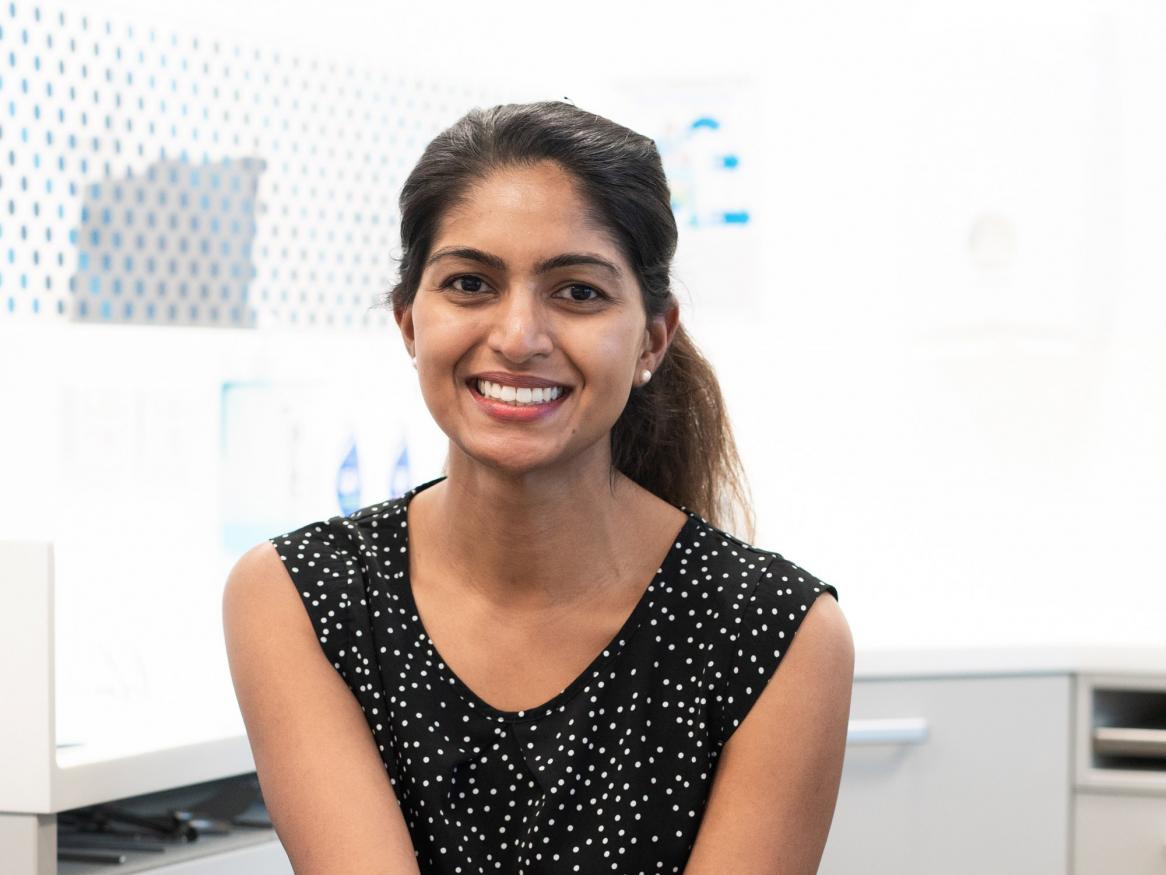 A portrait of Dr Kumarasinghe smiling in a dental office
