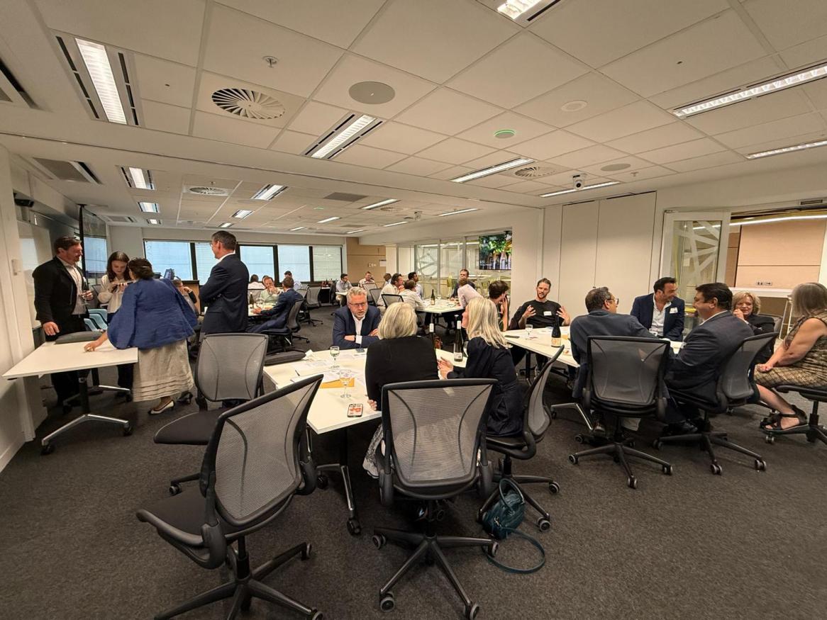 A large room in which groups of professionals are in animated conversation