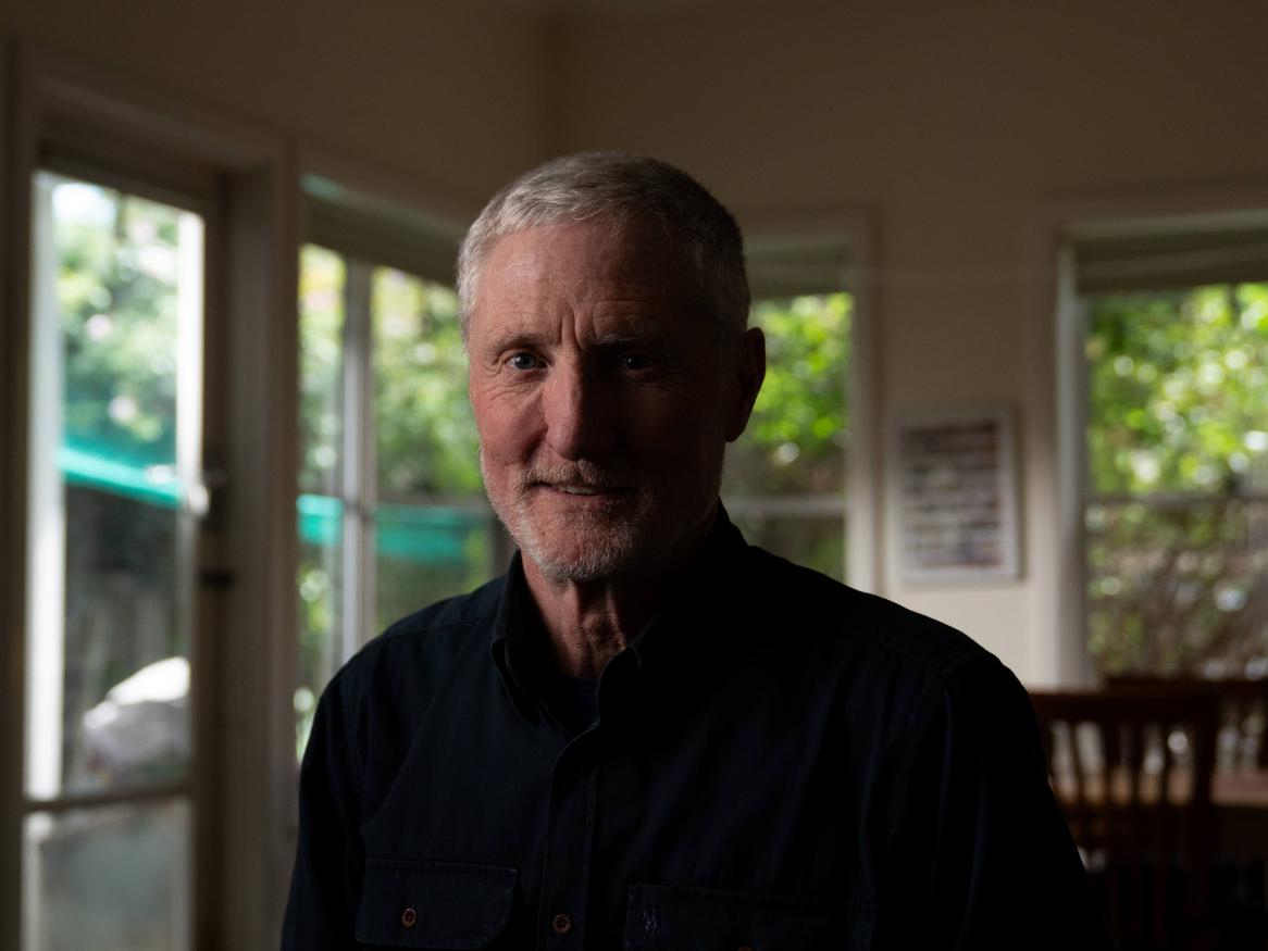 A portrait of David smiling in his home