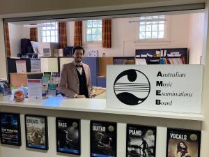 An AMEB staff member standing at the counter in the office