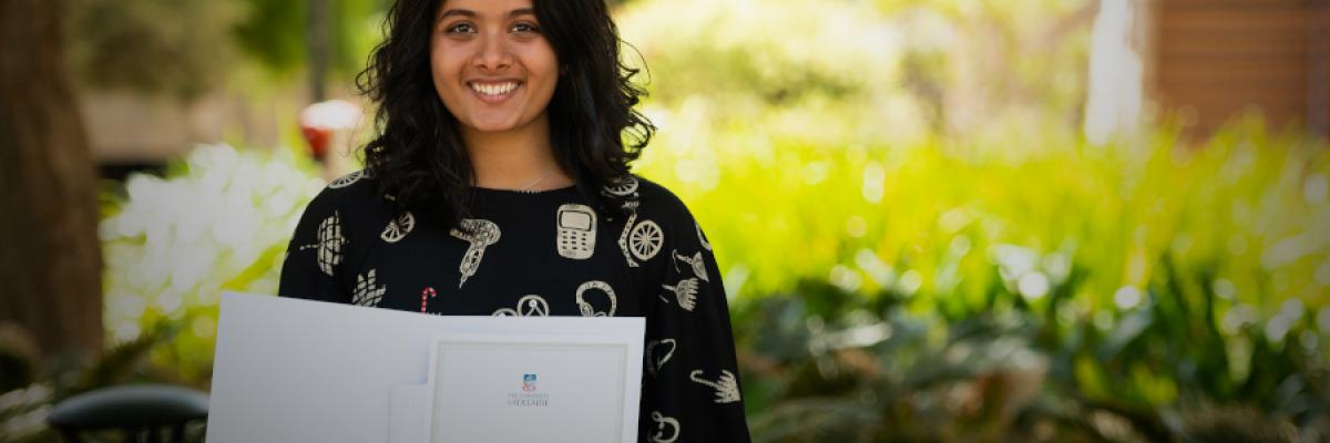 student holding ameb prize certificate