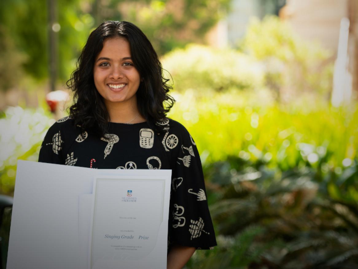 student holding ameb prize certificate