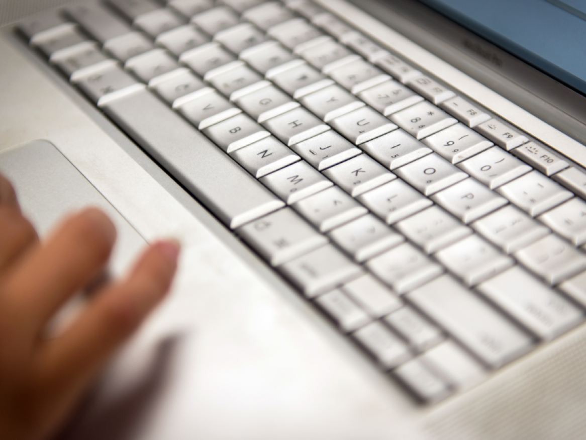 Hands using a laptop keyboard