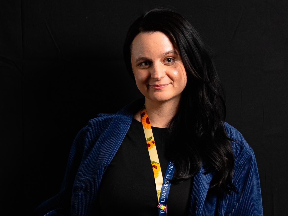 white woman with long black hair and sunflower lanyard