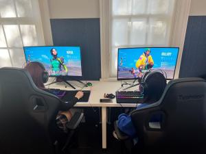 Landscape photo of two people playing in the Esports room of NT Campus