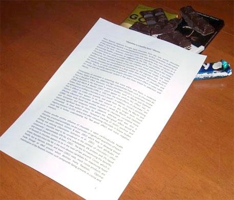 Chocolate underneath an essay paper.