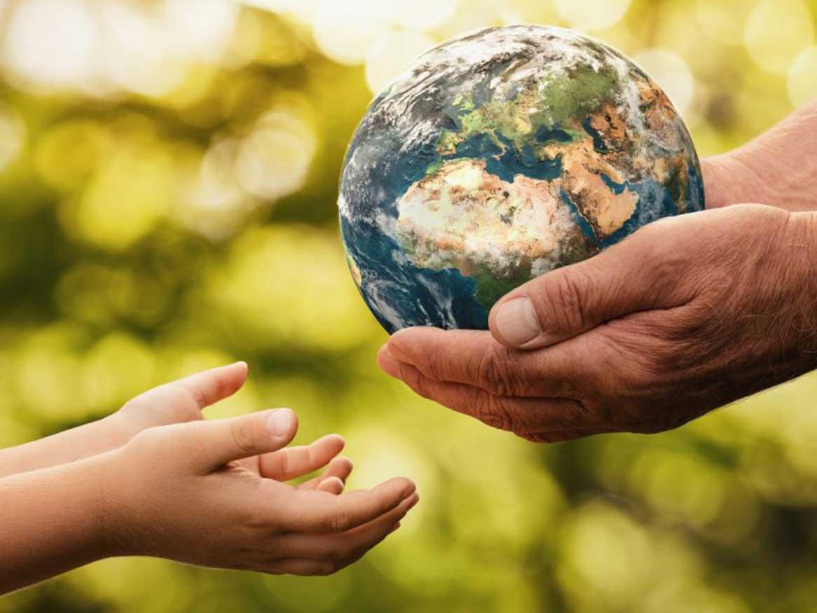 Mature hands holding the earth, passing onto the younger generation (young hands)