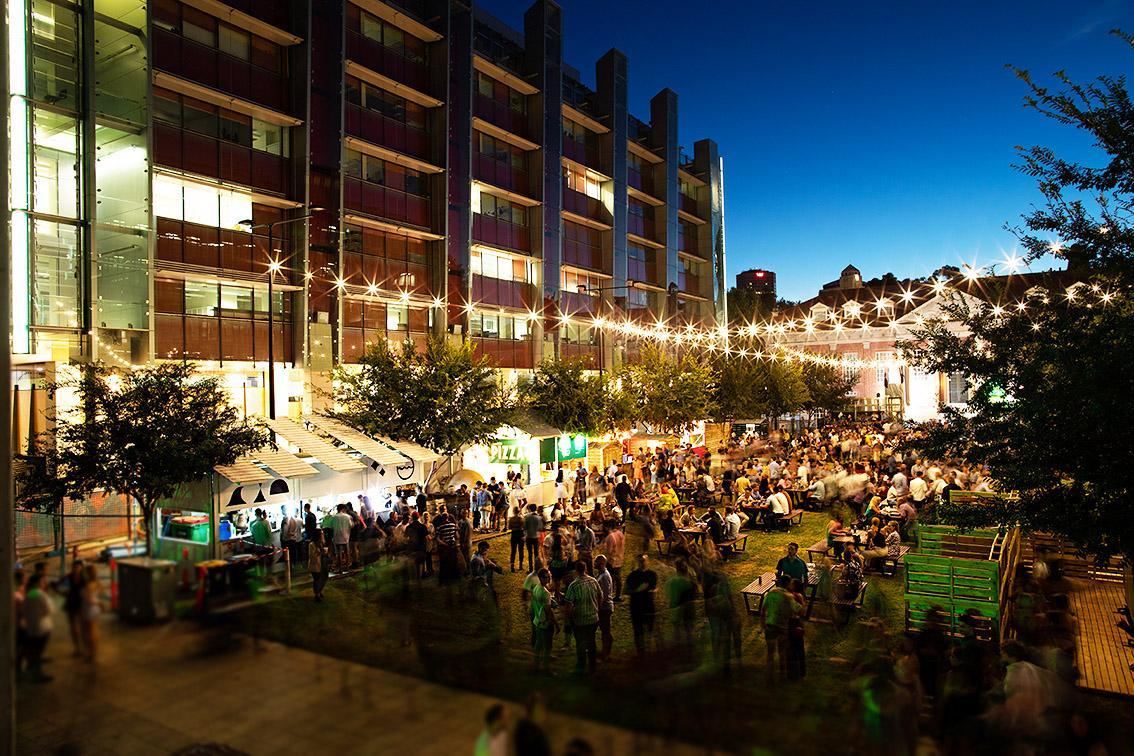 Nighttime photo of Maths Lawns with festival activities underway