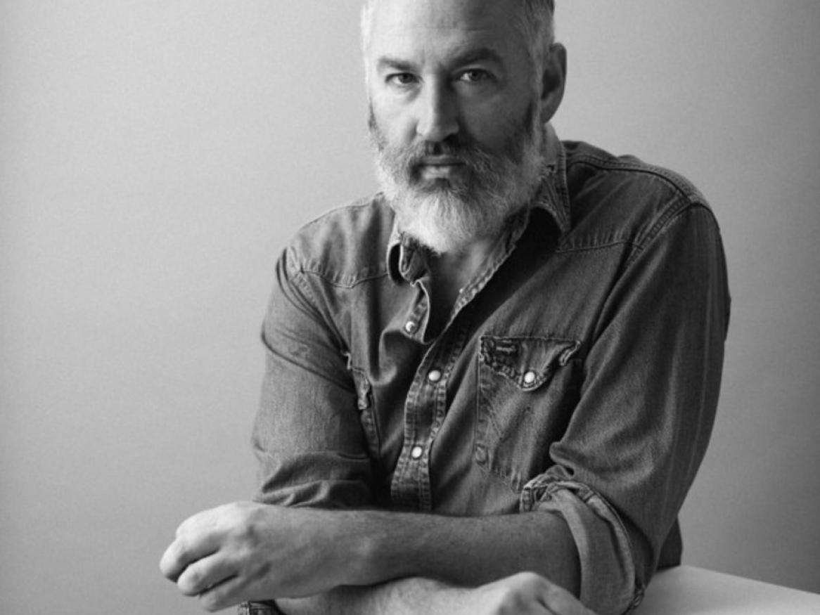 Black and white photo of a man sitting looking directly at the camera