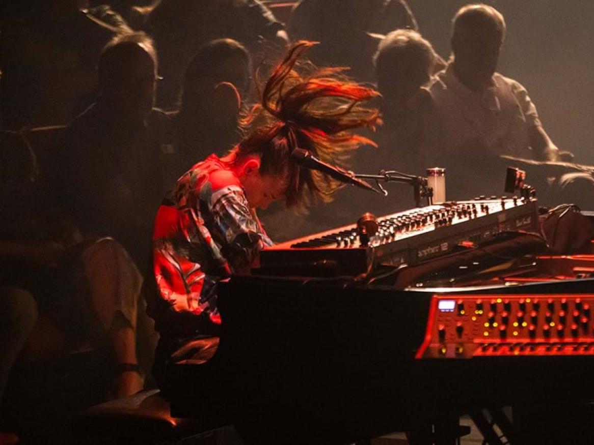 A woman in motion while playing a keyboard