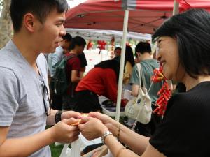 Professor Jacqueline Lo (PVCI) handing money packets (with chocolate coins) to Oscar Ong, SRC President