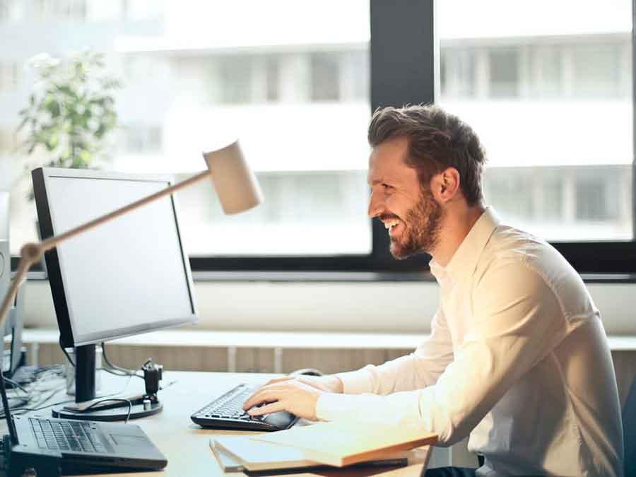 Smiling man on a desktop computer