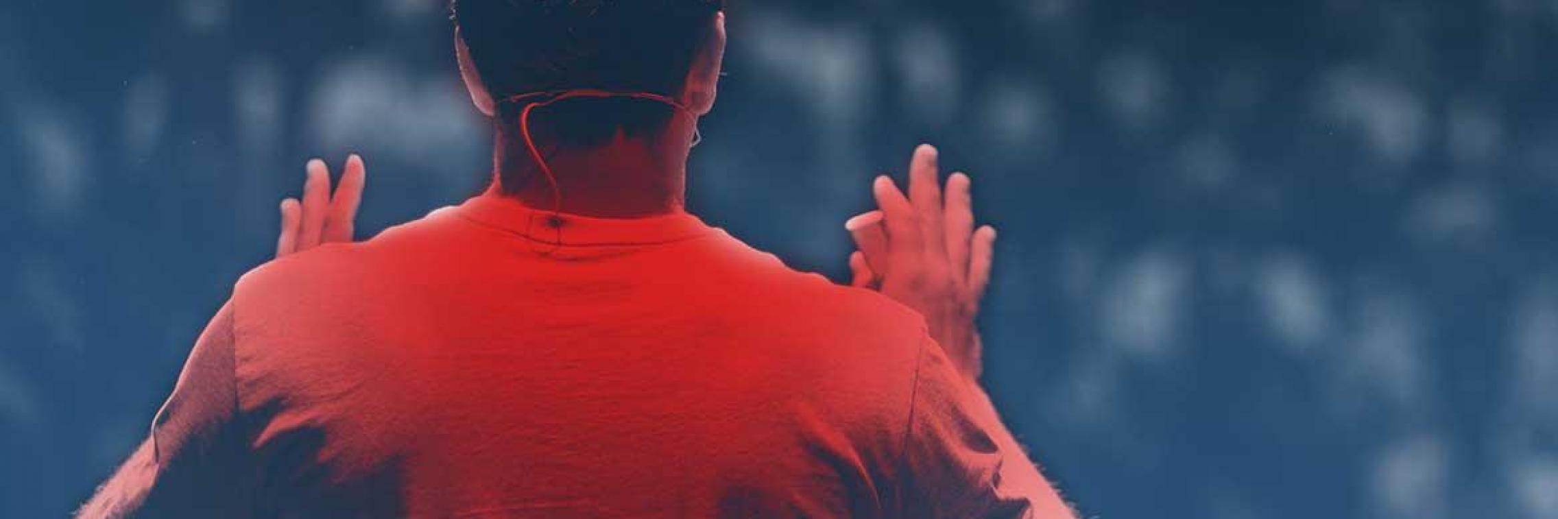 Guy in red shirt with his back to the viewer presenting