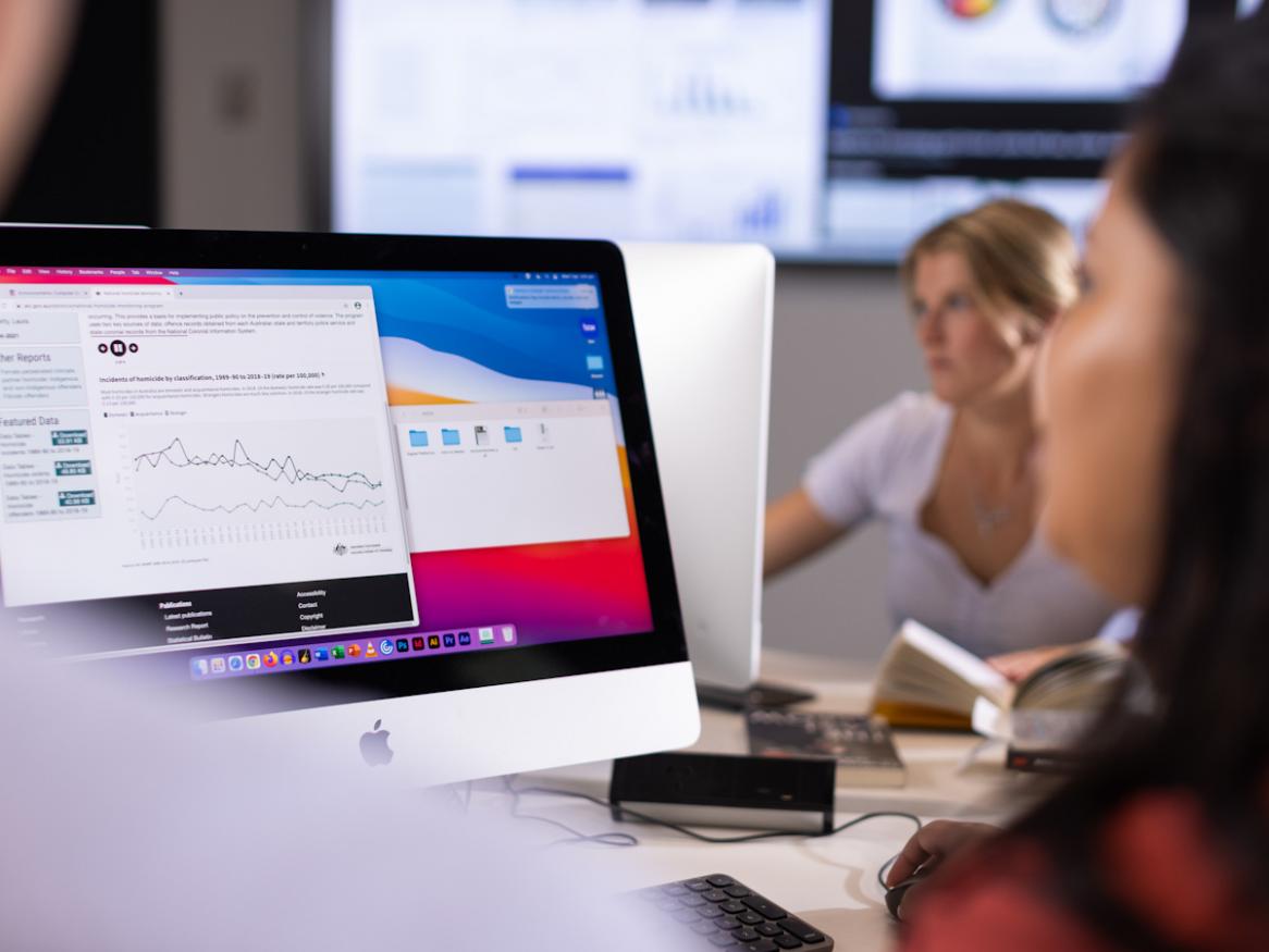 A woman looks at a computer screen.