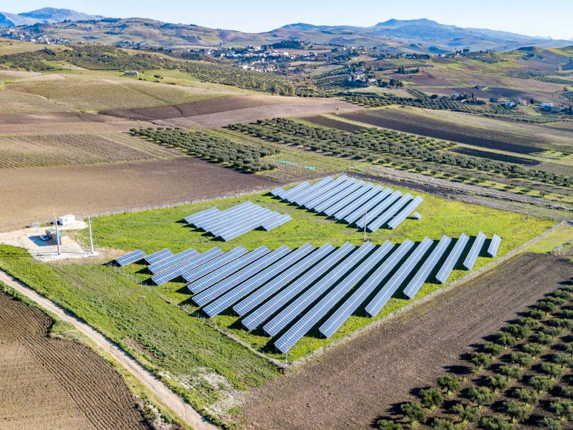 An image of a solar panel array in a rural area.
