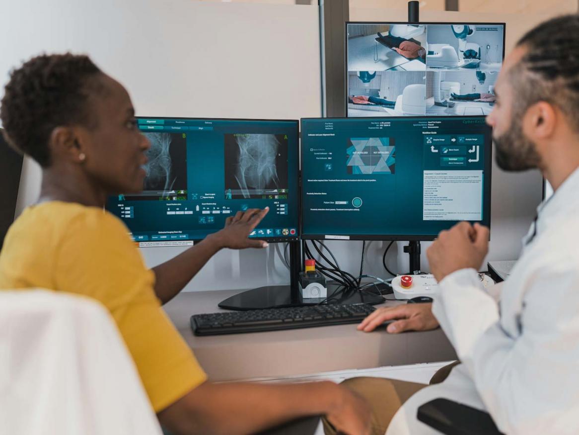 Two medical practitioners review medical images.