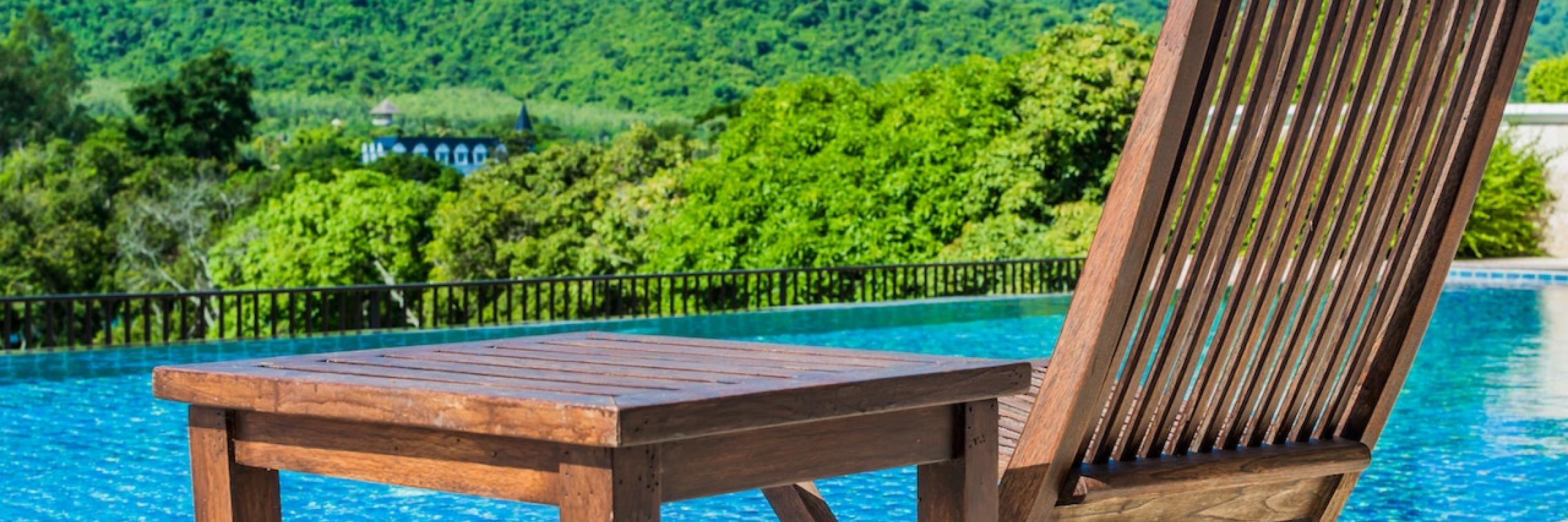 image shows chair next to blue lake looking towards hills