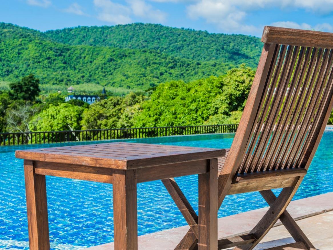 image shows chair next to blue lake looking towards hills