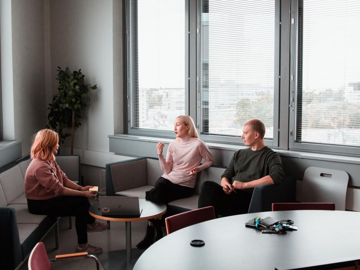 Three people sitting on a couch having a discussion