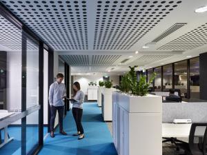 Photo of two people talking while standing in ThincLab office space