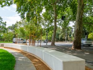 Photo of concrete bench (curved) and some shady trees